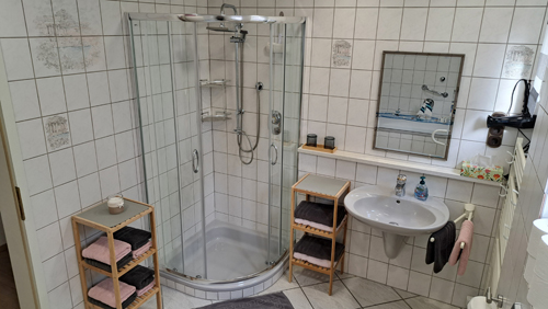 Im geräumigen Badezimmer sind Dusche und WC, ausgestattet mit Föhn, Handtuchtrockner, Toilettenpapier, Handtücher, Seife und Kosmetiktücher.